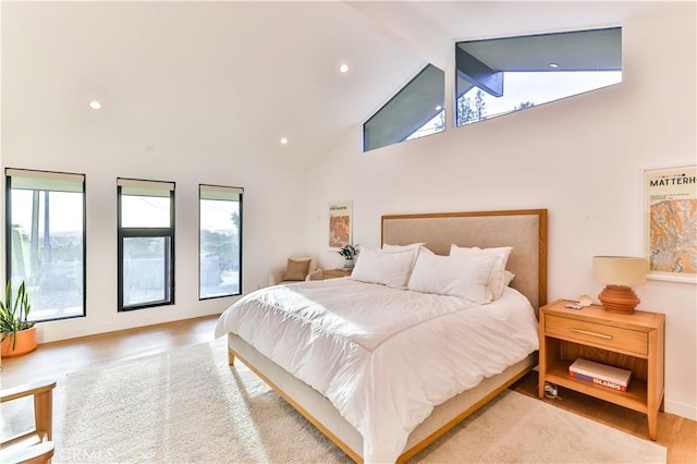 bedroom featuring hardwood / wood-style flooring and vaulted ceiling with beams