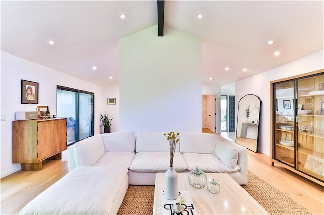 living room with light wood-type flooring and vaulted ceiling with beams