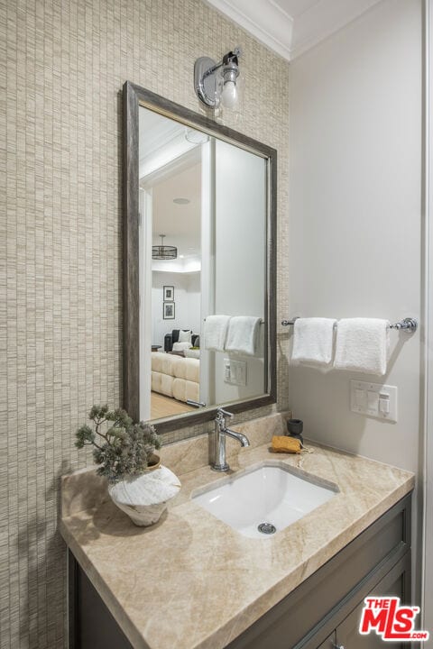 bathroom with vanity and ornamental molding