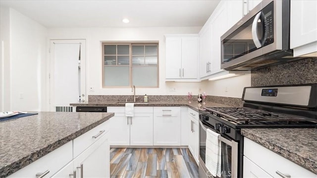 kitchen featuring appliances with stainless steel finishes, white cabinetry, and light hardwood / wood-style floors