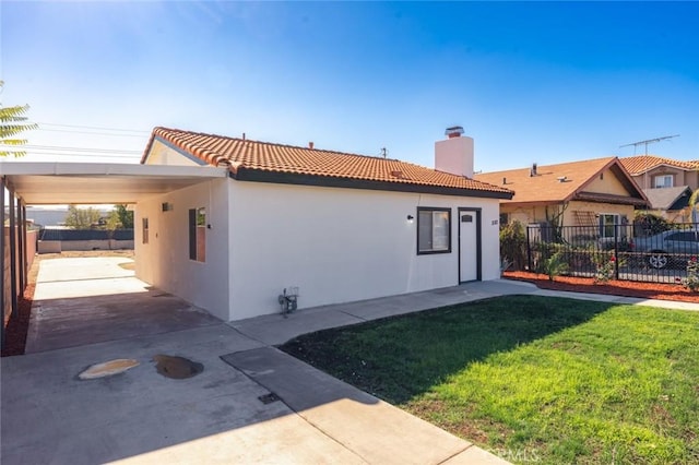 exterior space featuring a carport and a lawn