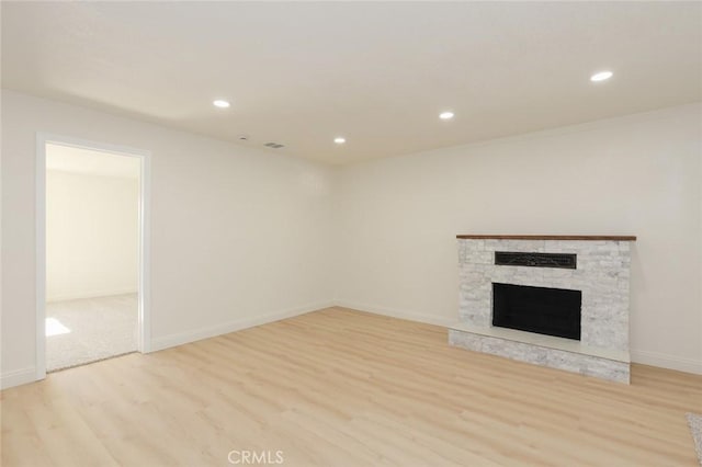 unfurnished living room featuring a fireplace and light hardwood / wood-style flooring