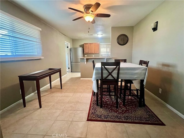 dining space with ceiling fan and light tile patterned floors