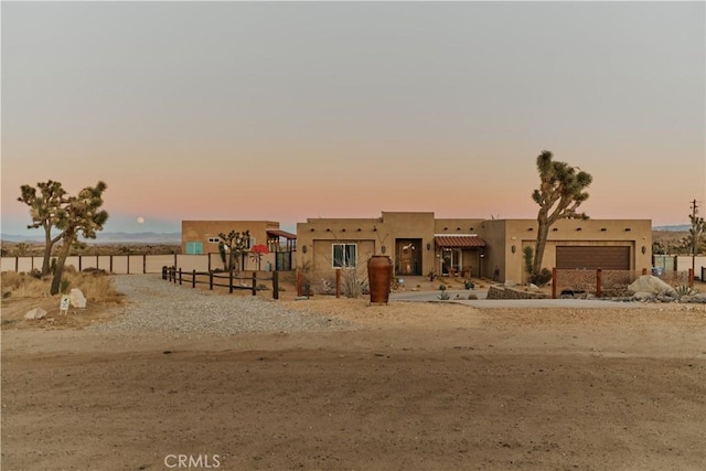 pueblo-style home featuring a garage