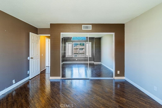 spare room featuring dark wood-type flooring