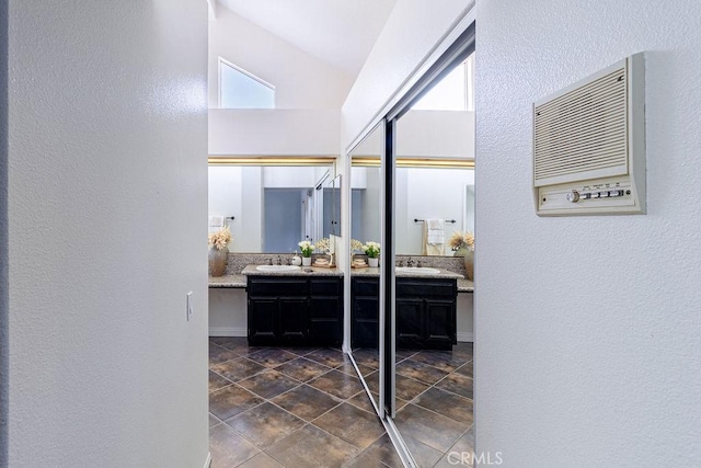 bathroom with vaulted ceiling and vanity