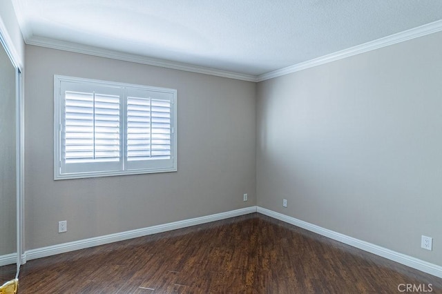 spare room with dark hardwood / wood-style flooring and crown molding