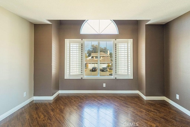 spare room with dark wood-type flooring