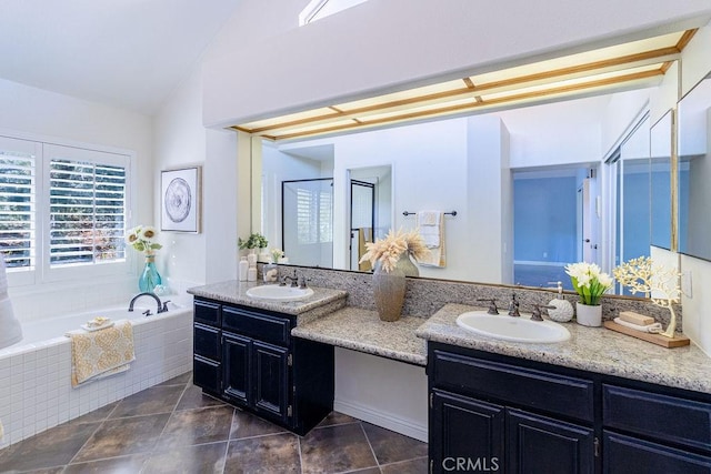 bathroom featuring lofted ceiling, vanity, and tiled bath