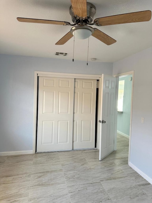 unfurnished bedroom featuring ceiling fan and a closet