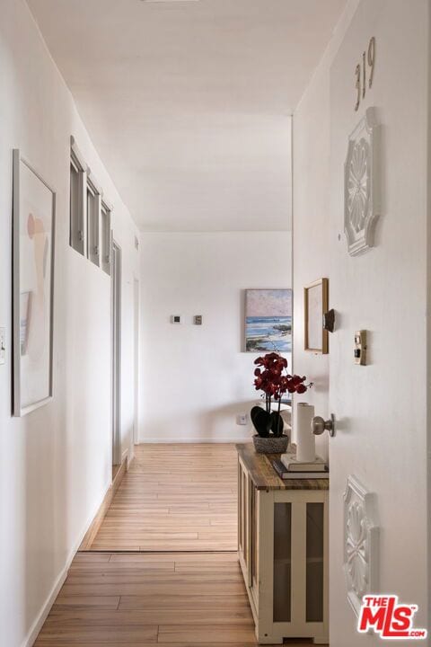 hallway with a healthy amount of sunlight and light wood-type flooring