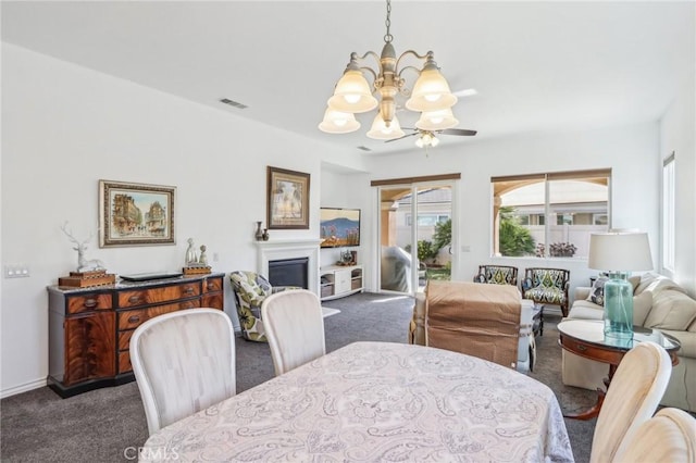 dining area featuring ceiling fan with notable chandelier and carpet flooring