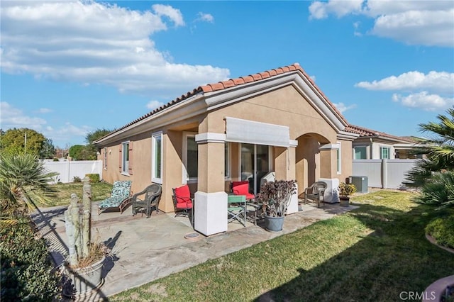 rear view of house featuring a lawn and a patio area