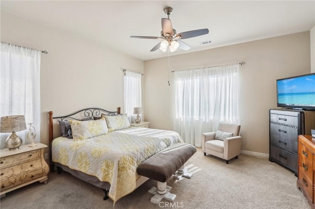 bedroom with ceiling fan and light carpet