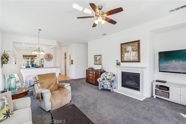 living room with carpet floors and ceiling fan with notable chandelier