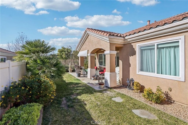 view of side of property with a lawn and a patio area