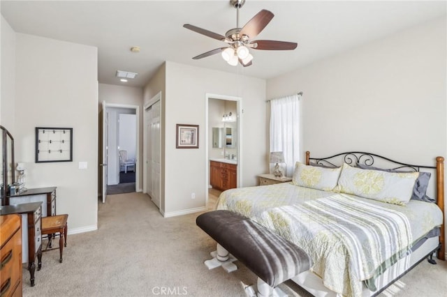 carpeted bedroom with ensuite bathroom and ceiling fan