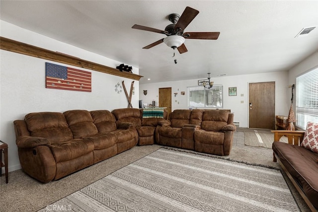 carpeted living room with ceiling fan with notable chandelier and baseboard heating