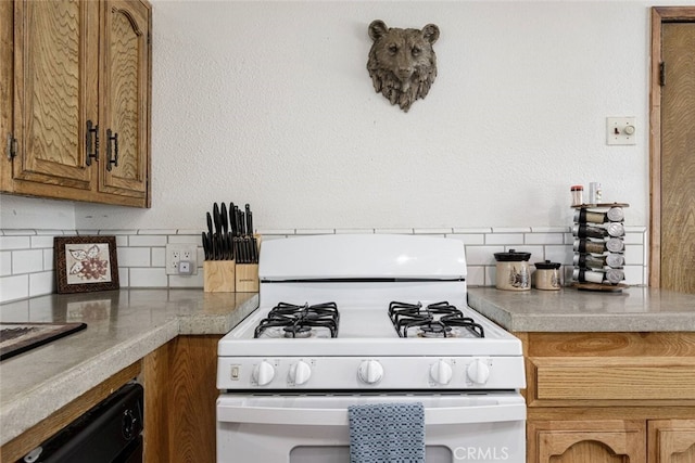 kitchen featuring dishwasher, white range with gas cooktop, and backsplash