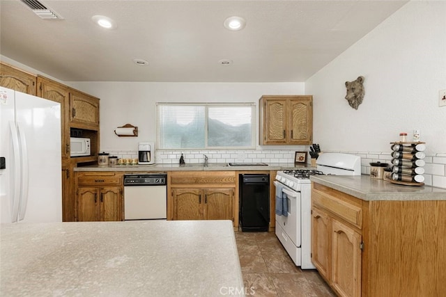 kitchen featuring white appliances, backsplash, and sink