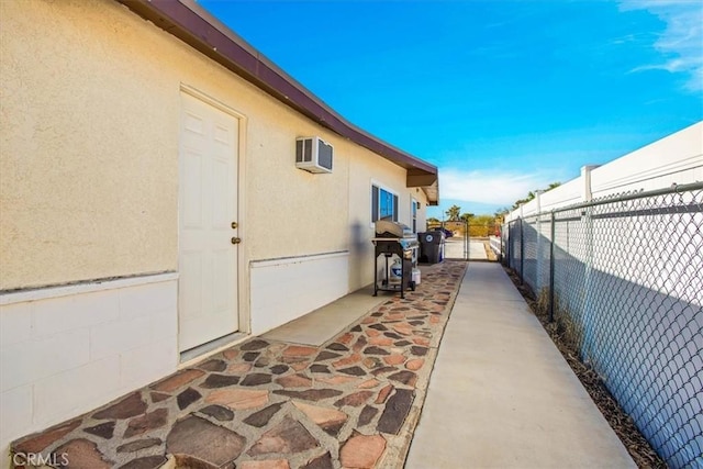 view of side of property with an AC wall unit and a patio