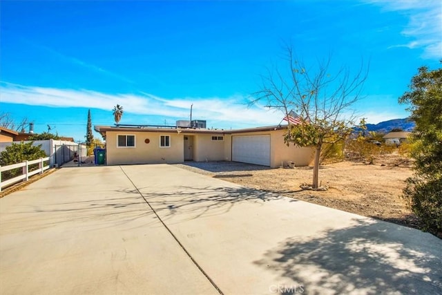 ranch-style house featuring a garage and solar panels