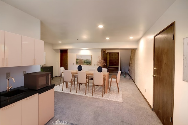 dining space with sink and carpet flooring