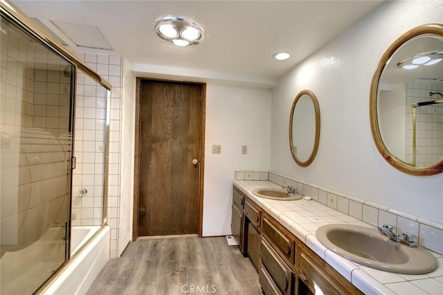 bathroom featuring vanity, wood-type flooring, and shower / bath combination with glass door