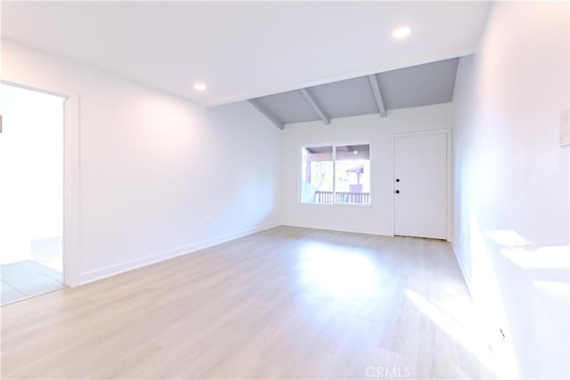 unfurnished room with light hardwood / wood-style floors and vaulted ceiling with beams