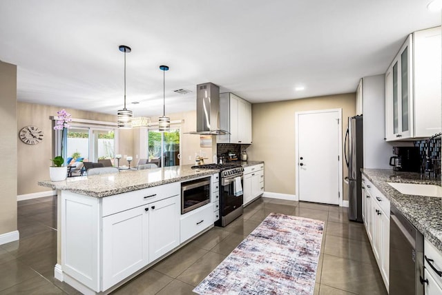 kitchen featuring stainless steel appliances, white cabinetry, exhaust hood, and light stone countertops