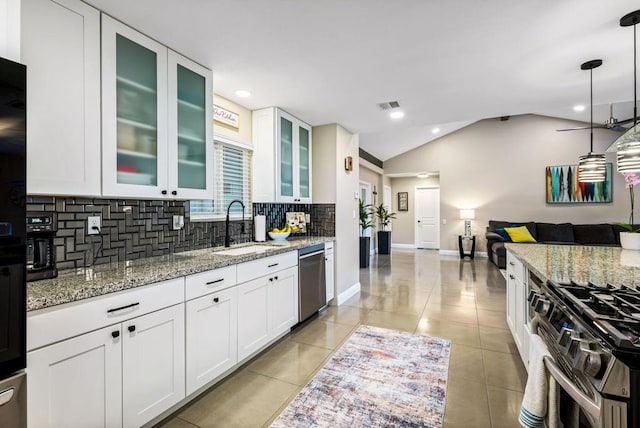 kitchen with light stone countertops, pendant lighting, white cabinets, appliances with stainless steel finishes, and sink