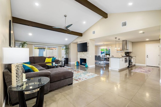 living room with beamed ceiling, light tile patterned floors, ceiling fan, high vaulted ceiling, and a fireplace