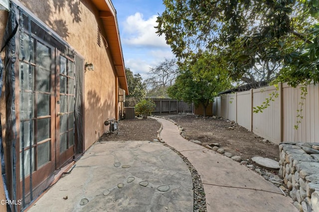 view of yard featuring central AC unit and a patio