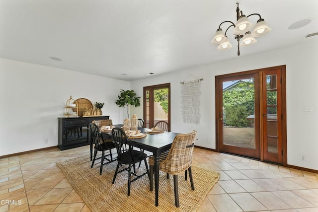 dining space with light tile patterned floors and an inviting chandelier