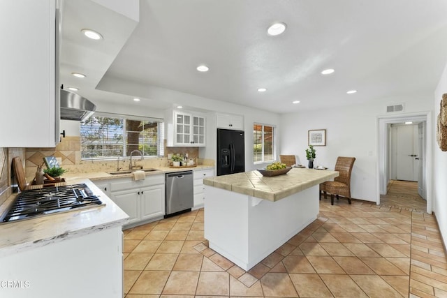 kitchen featuring sink, a breakfast bar, white cabinetry, stainless steel appliances, and extractor fan