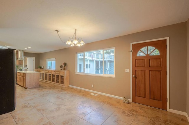 tiled entryway featuring a chandelier