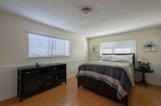 bedroom featuring a textured ceiling and light hardwood / wood-style flooring