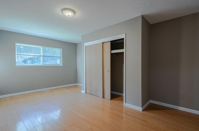 unfurnished bedroom featuring a closet and light hardwood / wood-style flooring