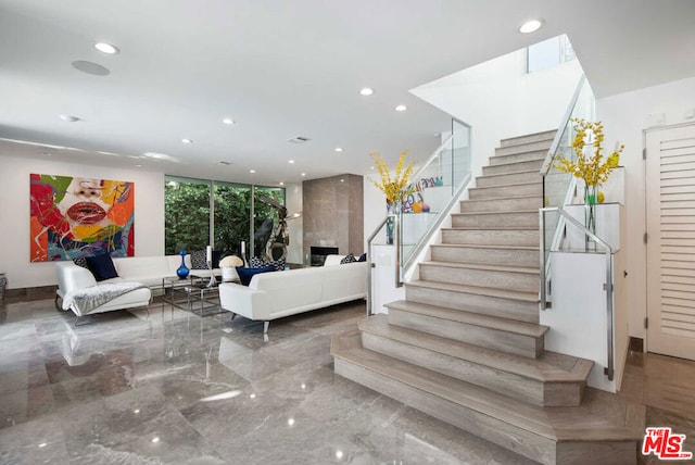 stairs with a high end fireplace and expansive windows