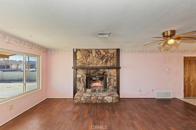 unfurnished living room with a textured ceiling, ceiling fan, a fireplace, and hardwood / wood-style flooring