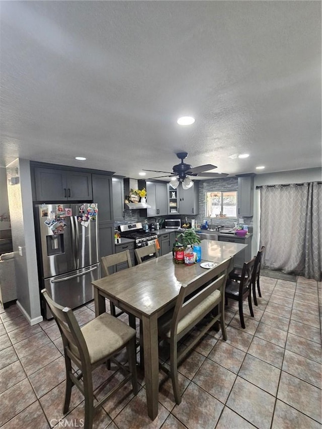 tiled dining room featuring ceiling fan and a textured ceiling