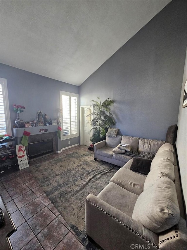 living room featuring vaulted ceiling, a textured ceiling, and dark tile patterned flooring