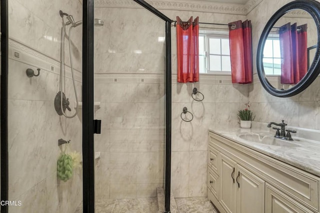 bathroom with tile walls, vanity, and a shower with shower door