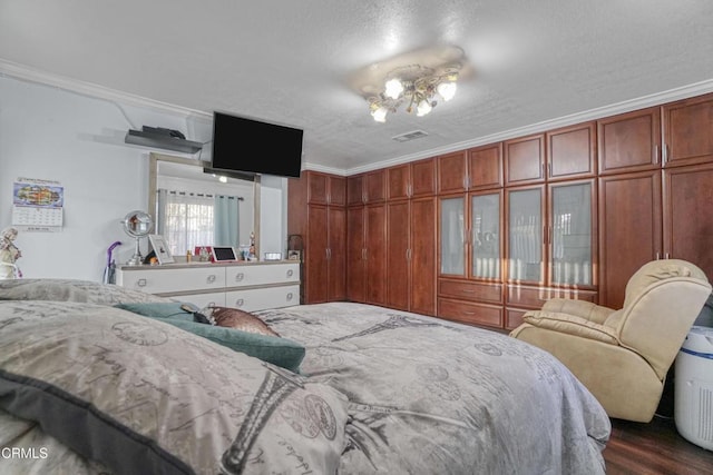 bedroom with a textured ceiling, crown molding, and dark hardwood / wood-style floors