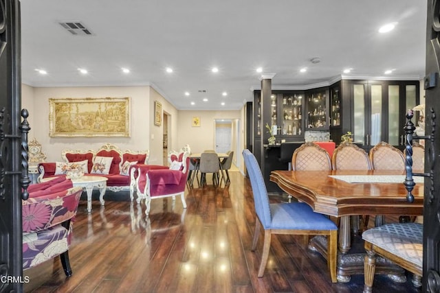 dining space with ornate columns, hardwood / wood-style flooring, and crown molding