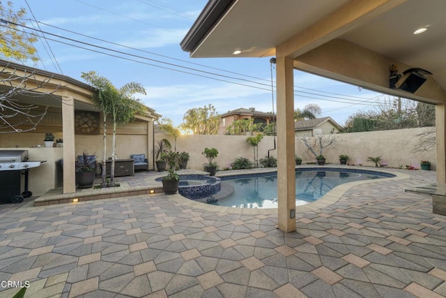 view of swimming pool featuring a grill, an in ground hot tub, and a patio area