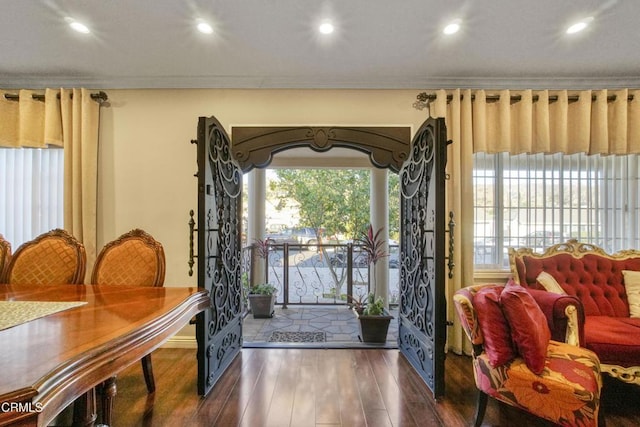 entrance foyer with a wealth of natural light, crown molding, and dark hardwood / wood-style floors