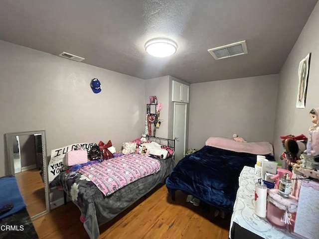 bedroom with hardwood / wood-style flooring and a textured ceiling