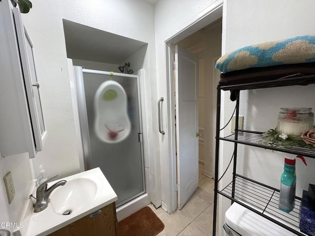 bathroom featuring an enclosed shower, vanity, tile patterned flooring, and toilet