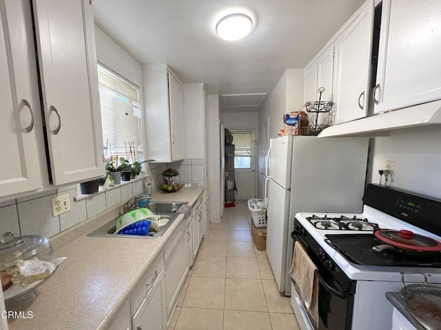 kitchen with range with gas cooktop, white cabinets, light tile patterned floors, and tasteful backsplash